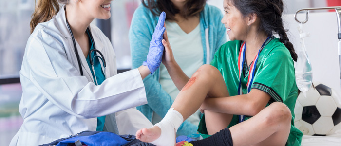 a little girl with a shin injury giving a doctor a high five